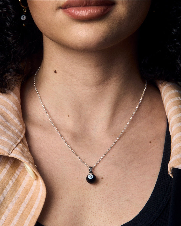 Silberne Halskette mit feiner Gliederkette, versehen mit einem kleinen 8-Ball-Billard-Anhänger aus glänzendem Material