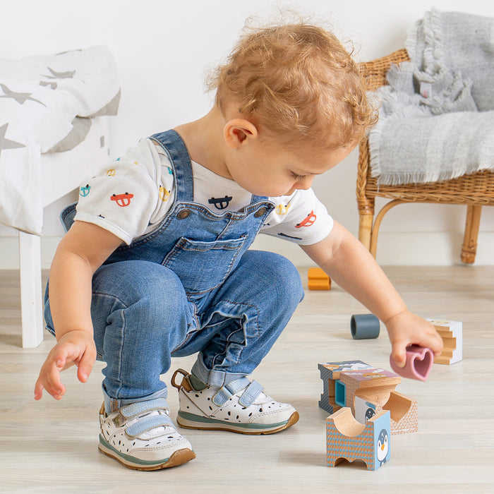 Child playing with toys on a wooden floor in a home setting