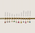 LLUME Jewelry’s Birthstone Earrings feature twelve gold-plated earrings, each with a unique gemstone charm representing every month from January to December for a personalized touch.