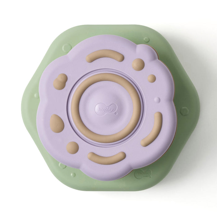 Children's toy with a purple top and green base on a white background