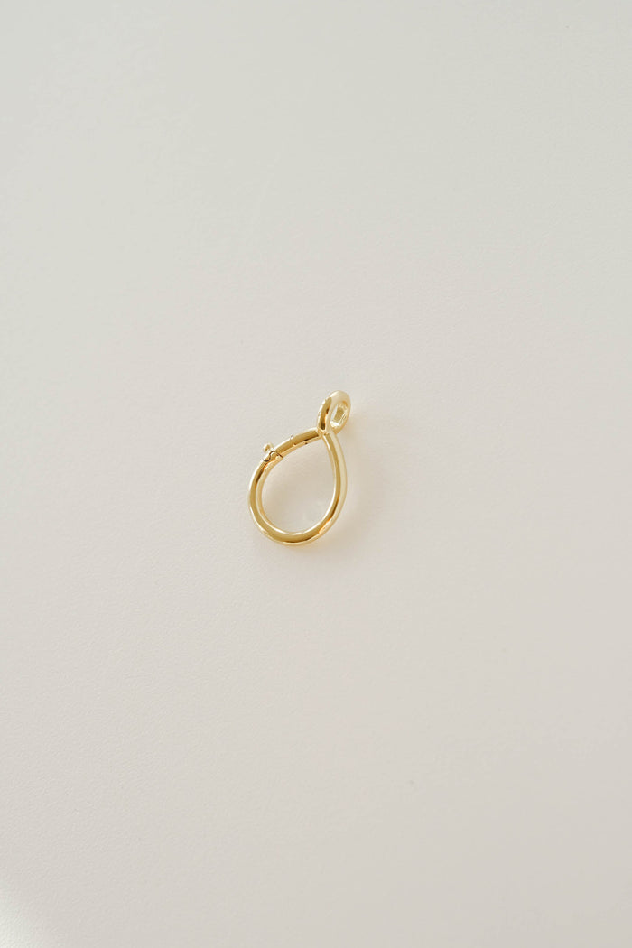 The LLUME Jewelry Charm Holder features a single 18K gold filled teardrop-shaped pendant on a light surface, ideal as a necklace accessory or for holding charms.