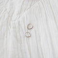 Two Classic Pointed Hoop Silver earrings by LLUME Jewelry, crafted in 925 silver with an irregular shape, rest on a softly textured white crinkled fabric background.