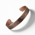 Engraved copper magnetic cuff bracelet with adjustable open back design and magnetic inserts on a white background