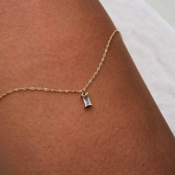 The Daylight Necklace by LLUME Jewelry is a delicate gold plated piece featuring a small rectangular gemstone pendant that shines beautifully when worn alone.