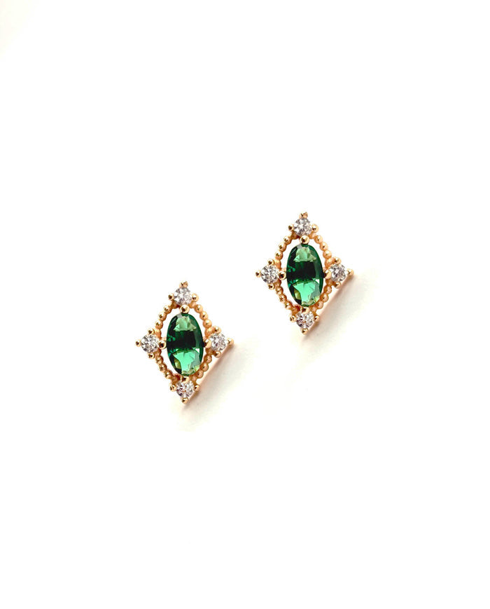 The Destiny Earrings by LLUME Jewelry are gold studs with central oval emerald green gems, accented by small white stones in a square arrangement for an elegant, jewel-toned look.
