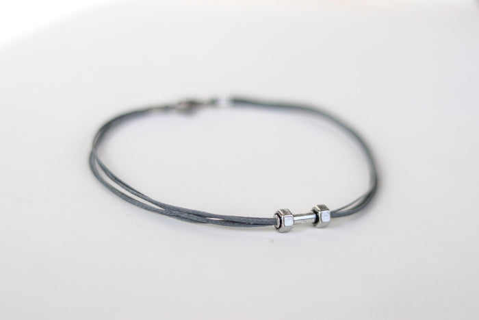 gray cord anklet with a silver-tone dumbbell charm