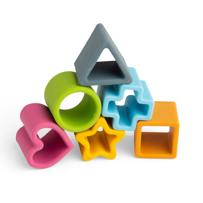Colorful set of geometric-shaped silicone sand molds on a white background