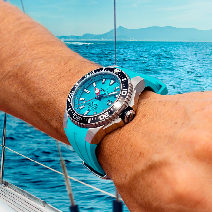 Festina turquoise diver watch worn on the wrist beside the sea with a turquoise silicone strap