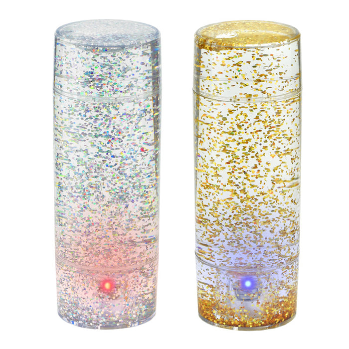 Two cylindrical LED lights, one with multicolor glitter and the other with gold glitter, on a white background.