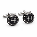 Pair of black gear shift cufflinks with silver posts on a white background