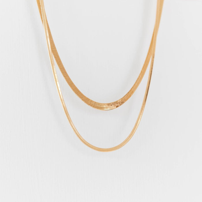 The Hailey Duo by LLUME Jewelry features two simple, elegant gold necklaces that create a sophisticated set, beautifully displayed on a plain white background.