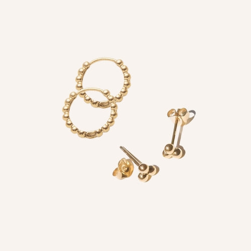 The LLUME Jewelry June-Prosecco Set features two pairs of gold earrings on a light background: textured Prosecco Beaded Hoops with small beads and elegant, round June Studs.