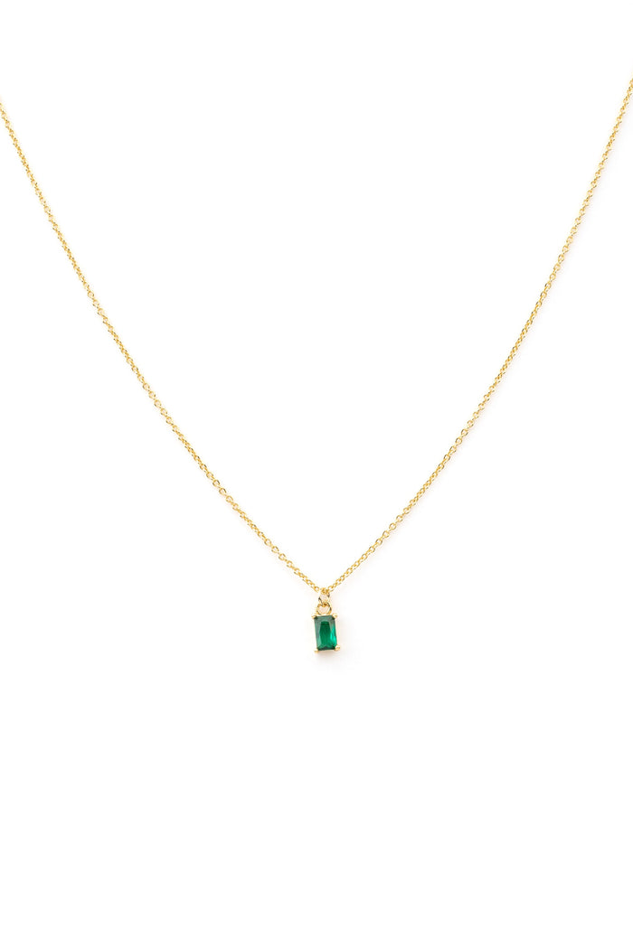 The Kismet Necklace features a gold-plated chain with a small rectangular emerald-green charm, shown on a white background.
