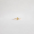 The Lila Ring by LLUME Jewelry features a minimalist 14k gold-filled band with a rectangular yellow gemstone, displayed against a light gray background.