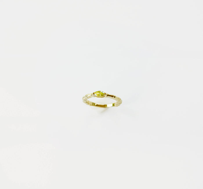 The Limon Ring by LLUME Jewelry is a gold-plated 925 sterling silver ring featuring a small, marquise-shaped lemon yellow gemstone, showcased against a plain white background.