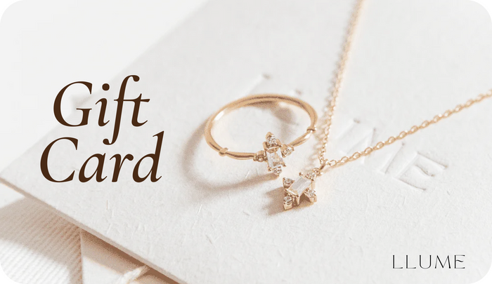 A gold ring and star-shaped necklace from LLUME Jewelry rest on a card reading “Gift Card,” showcasing the LLUME Gift Card’s elegance and convenience—no expiry for lasting peace of mind.