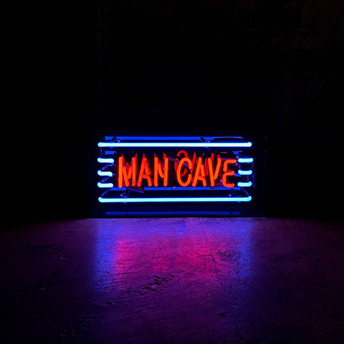 Man Cave neon sign glowing in a dark room with blue and red lighting
