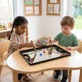 Two children playing with colorful magnetic toys on a tray at a table.