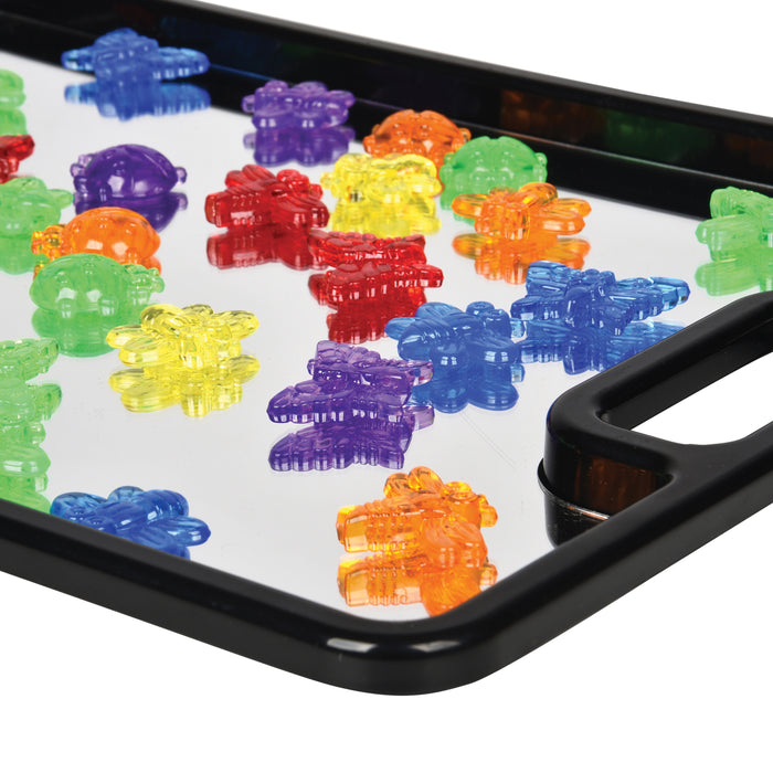 Colorful transparent pieces on a black tray with a white background