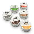 Six Mo Bros beard balm tins from the beard care gift set displayed on a white background