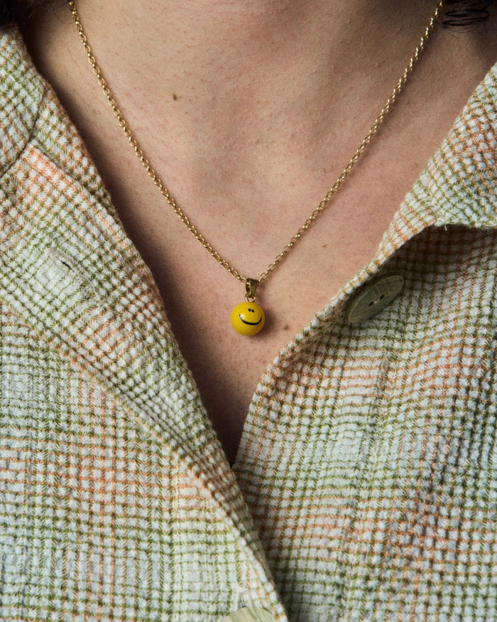 Halskette mit kleinem Smiley-Anhänger, feine Gliederkette kombiniert mit fröhlichem, gelbem Smiley-Motiv für ein verspieltes, lächelndes Design.