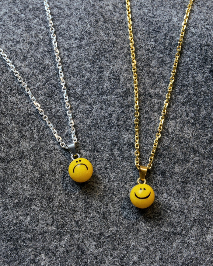 necklace with sad and happy smiley