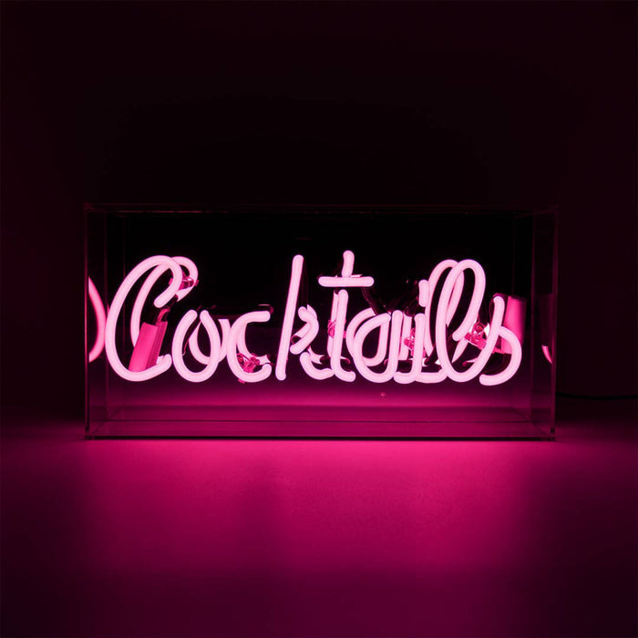 Pink Cocktails glass neon sign glowing inside a clear acrylic display box against a dark background