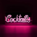 Pink Cocktails glass neon sign glowing inside a clear acrylic display box against a dark background