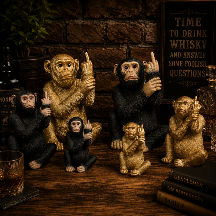 Collection of black and gold resin monkey ornaments displayed together in a warm home bar setting