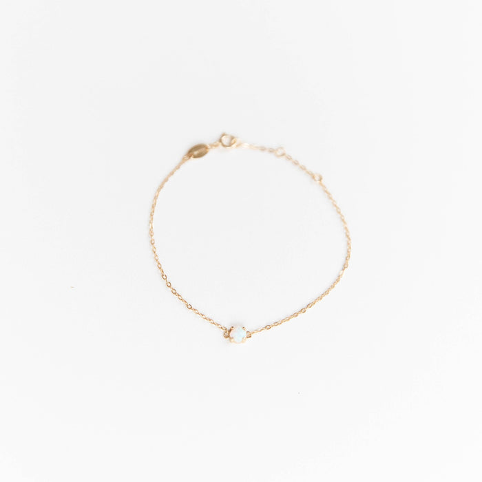 The Sardinia Bracelet by LLUME Jewelry features a delicate gold plated sterling silver chain with a small white gemstone centerpiece. This adjustable, dainty bracelet adds elegance to any look and is shown on a plain white background.