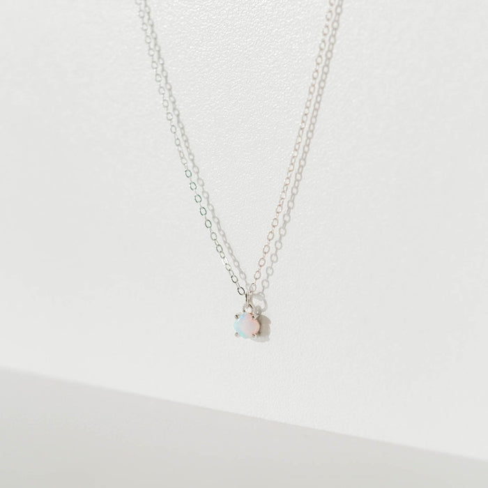 The Sardinia Necklace Silver by LLUME Jewelry is shown on a plain white background. Its delicate sterling silver chain and small round opal pendant are highlighted by soft shadows for an elegant, minimal look.