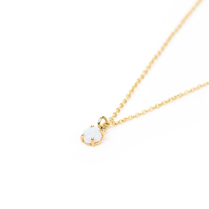 The Sardinia Opal Necklace by LLUME Jewelry features a delicate gold vermeil chain with a small white opal pendant in a gold prong setting, beautifully displayed on a white background.