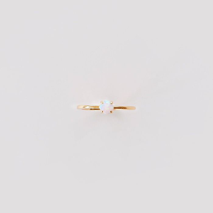 The Sardinia Ring by LLUME Jewelry features a small round opal set in a simple prong setting on 14k gold fill, shown against a plain light background.