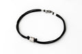 A black cord bracelet for men with a silver tube bead charm and a clasp closure.