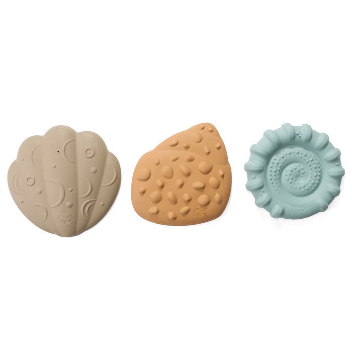 Three textured shell toys in beige, brown, and light blue on a white background