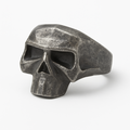 Stainless steel geometric skull ring with distressed matte finish on a white background.