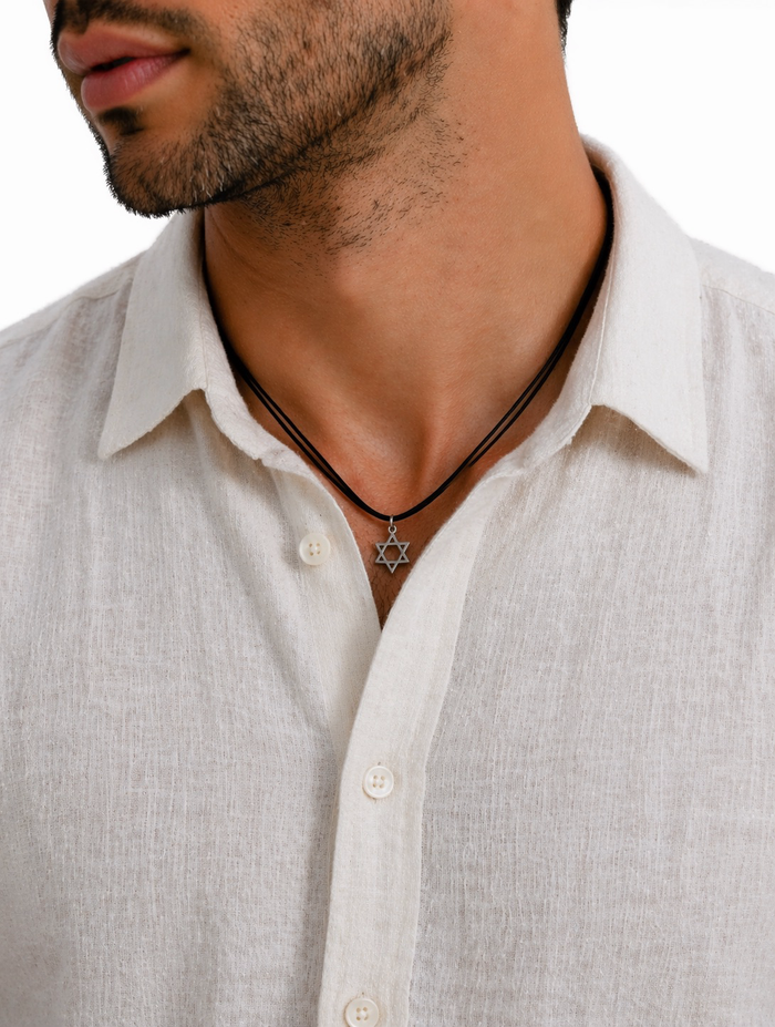Man wearing a necklace with a Star of David pendant on a white shirt.