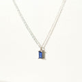 The Taylor Necklace Silver by LLUME Jewelry is a delicate sterling silver piece with a small rectangular sapphire blue charm pendant, shown against a plain white background.