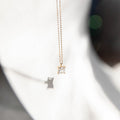The One Necklace by LLUME Jewelry features a delicate gold vermeil chain and a square-cut clear gemstone pendant, displayed in soft light with a gentle shadow on a white background.