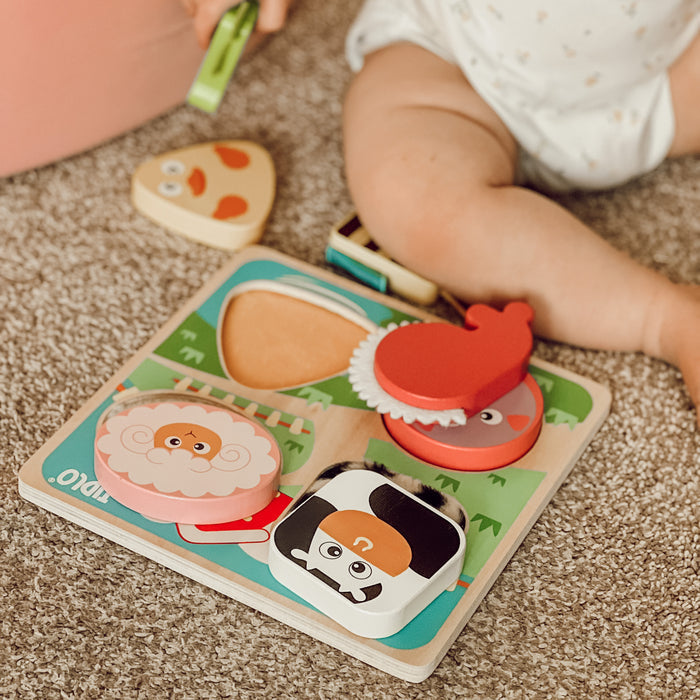 Child playing with a wooden puzzle toy on a carpeted floor