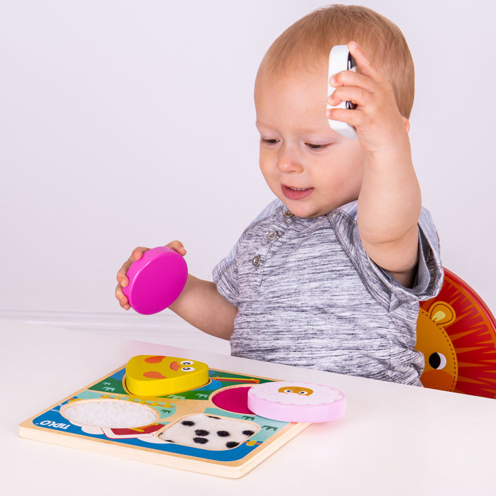 Child playing with a colorful puzzle on a white surface