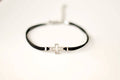 Women bracelet with silver outline cross charm, black cord - shani-adi-jewerly